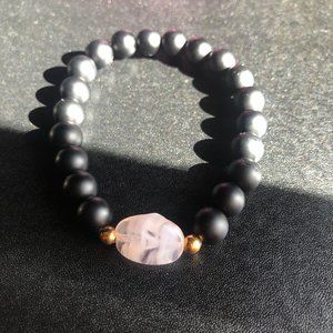 Light pink marbled glass gem and smooth black rock bracelet